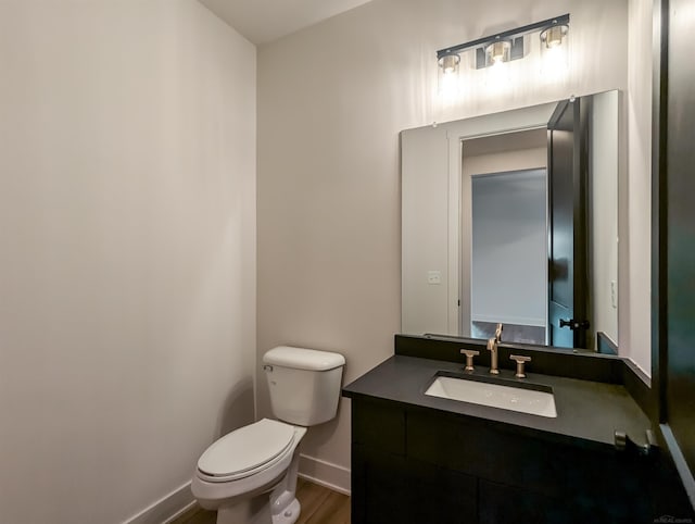 bathroom with hardwood / wood-style flooring, vanity, and toilet