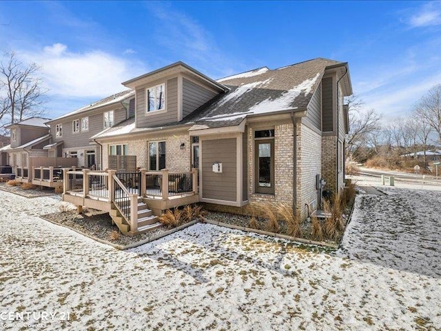 snow covered house with a wooden deck