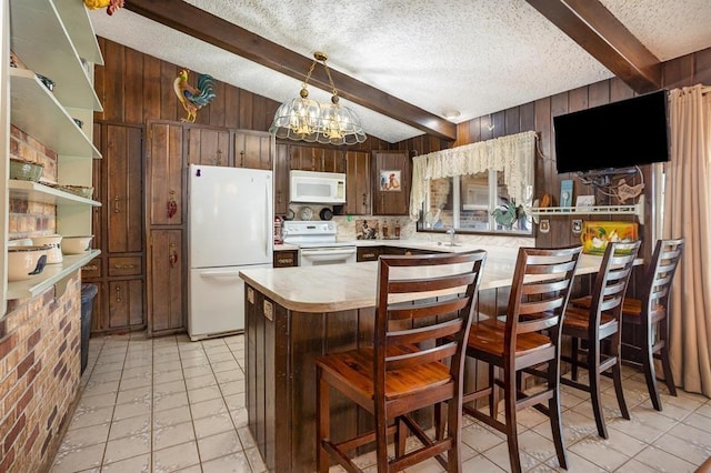 kitchen with wood walls, beamed ceiling, white appliances, and an inviting chandelier