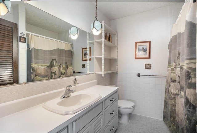 bathroom featuring curtained shower, tile patterned flooring, toilet, vanity, and tile walls