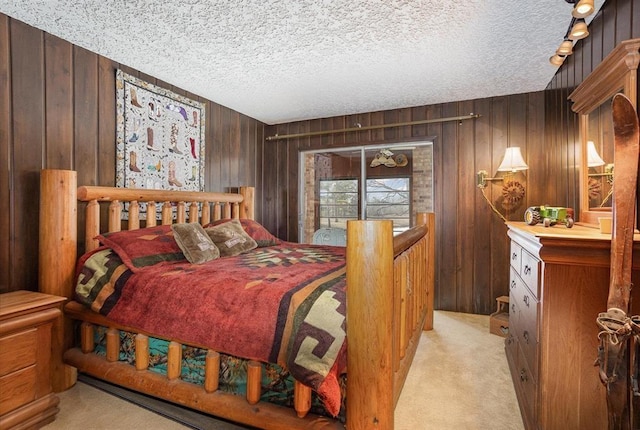 carpeted bedroom with wooden walls and a textured ceiling