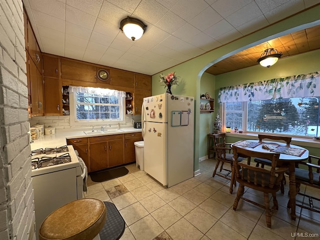 kitchen with white appliances, sink, and light tile patterned floors