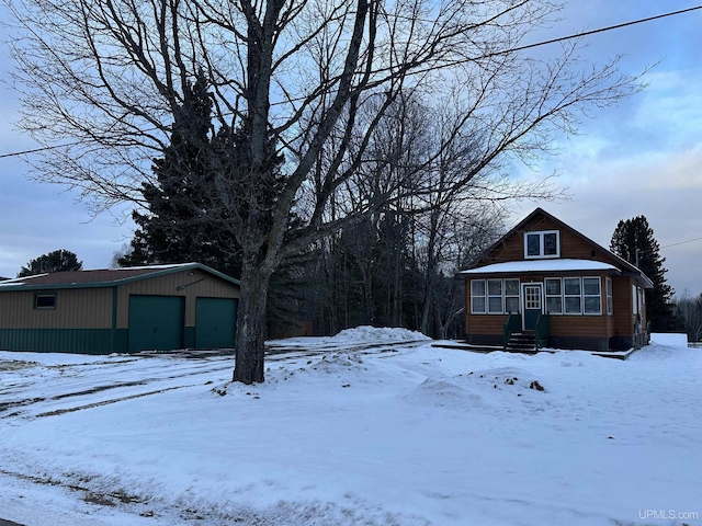 yard covered in snow with a garage and an outdoor structure