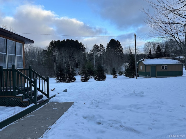 yard covered in snow featuring an outbuilding