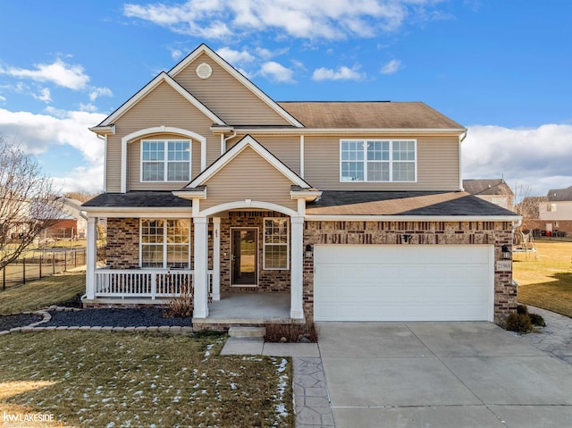 view of front of house featuring covered porch, a garage, and a front lawn