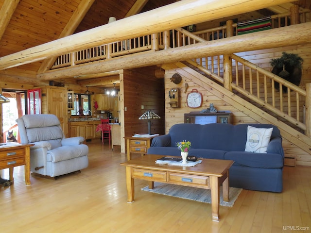 living room with wooden ceiling, light hardwood / wood-style floors, high vaulted ceiling, and wooden walls