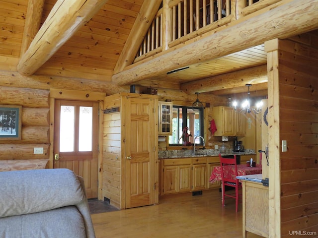 kitchen with hanging light fixtures, log walls, wooden ceiling, and a notable chandelier