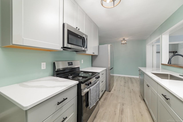 kitchen with sink, white cabinets, and appliances with stainless steel finishes