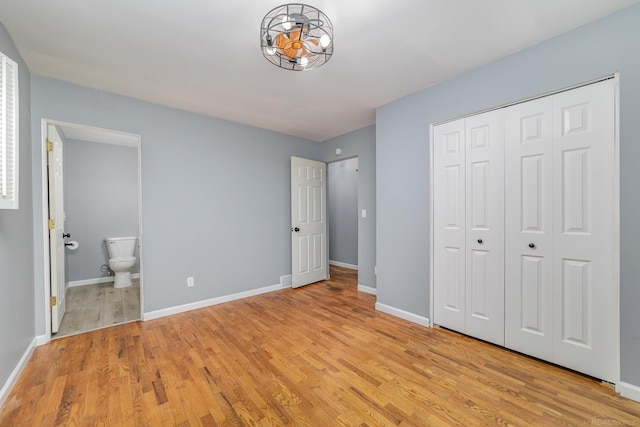 unfurnished bedroom featuring connected bathroom, light hardwood / wood-style floors, and a closet