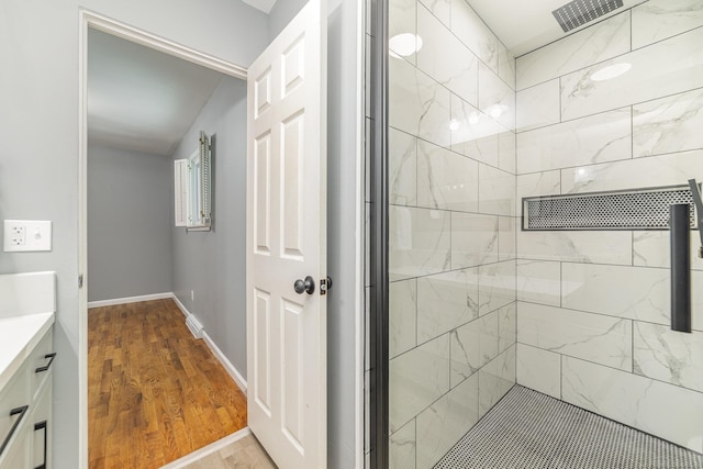 bathroom featuring vanity, wood-type flooring, and walk in shower