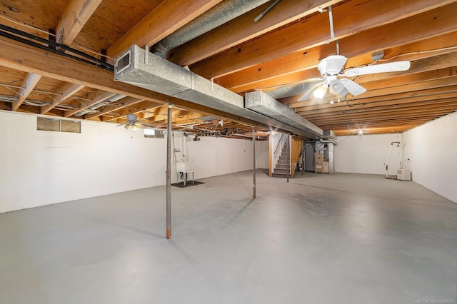 basement with ceiling fan, sink, and heating unit