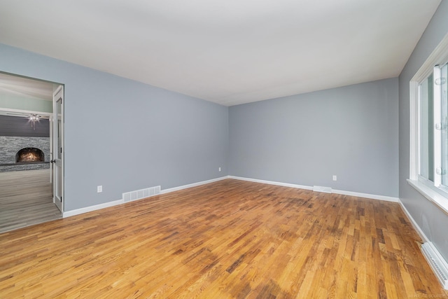 unfurnished room featuring a fireplace and light wood-type flooring