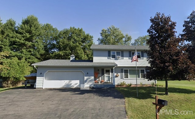 view of front of home with a front yard and a garage