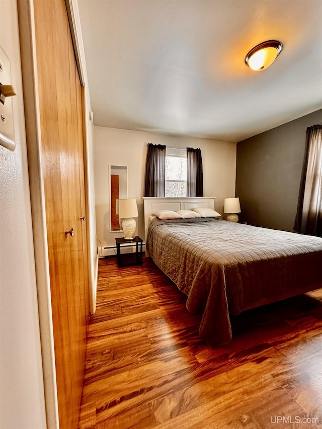 bedroom featuring wood-type flooring and baseboard heating