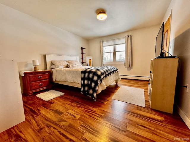 bedroom featuring baseboard heating and hardwood / wood-style floors