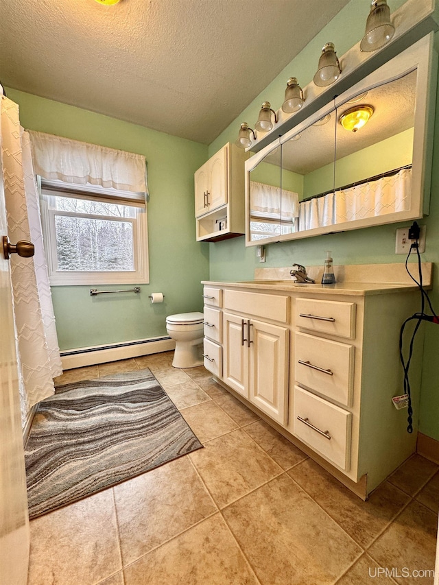 bathroom featuring tile patterned floors, a textured ceiling, vanity, baseboard heating, and toilet