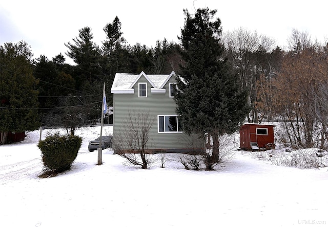 view of snowy exterior with a shed