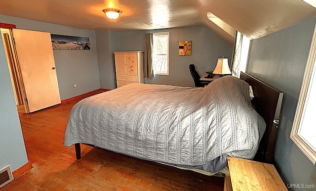 bedroom with hardwood / wood-style flooring and vaulted ceiling