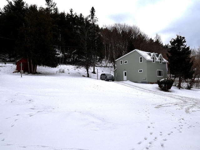 snowy yard featuring a storage shed