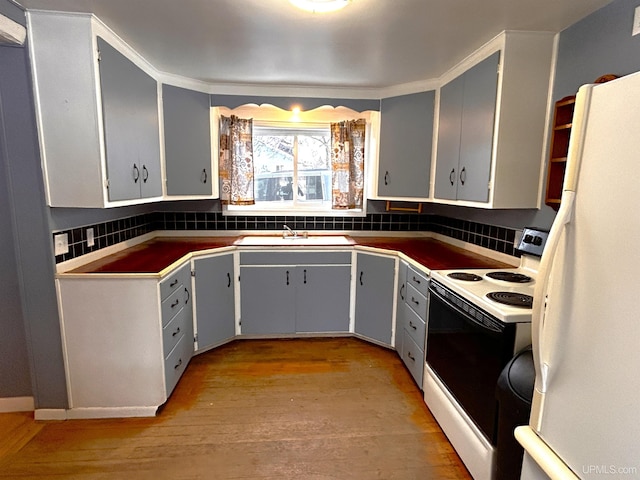 kitchen featuring light wood-type flooring, white appliances, sink, and tasteful backsplash