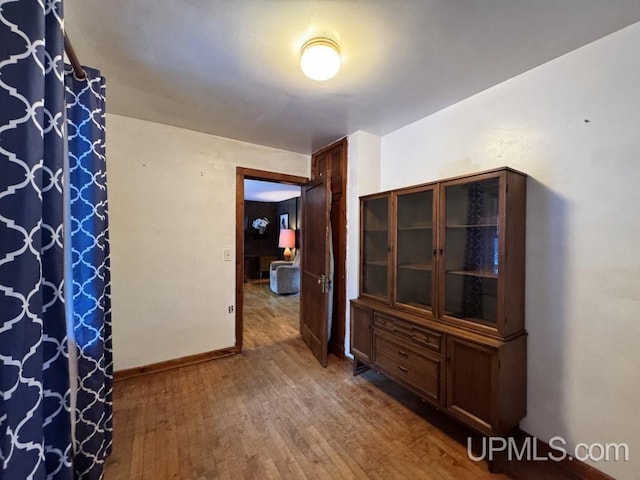 corridor with hardwood / wood-style flooring