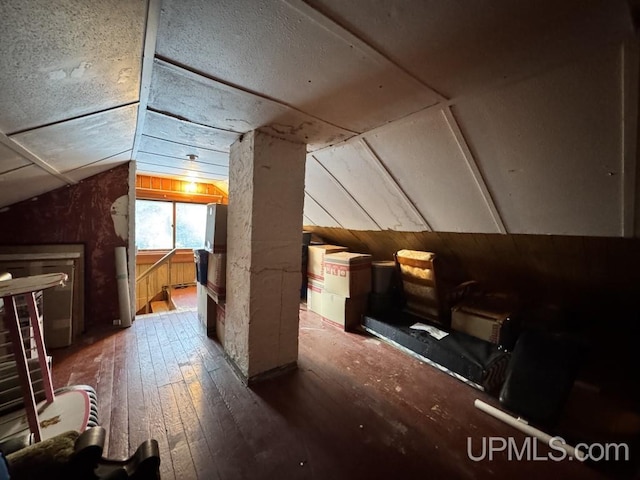 bonus room with wood-type flooring, lofted ceiling, and wooden walls