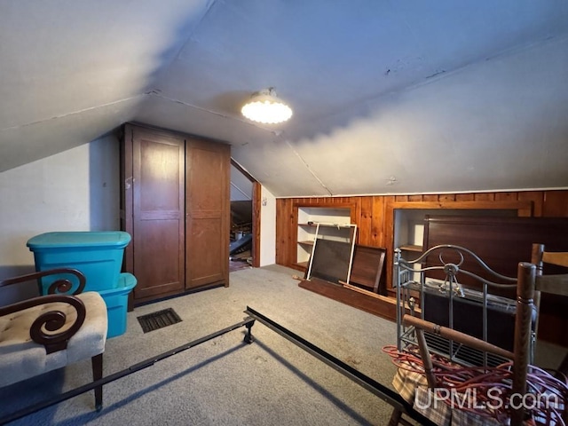 additional living space featuring lofted ceiling, light carpet, and wooden walls