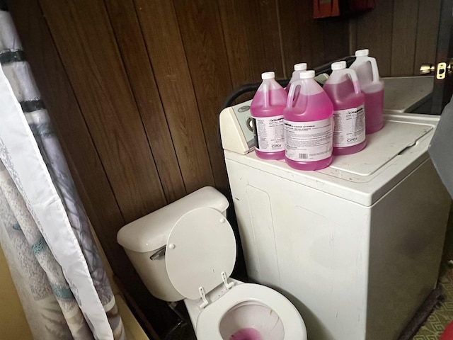 bathroom with wood walls and toilet