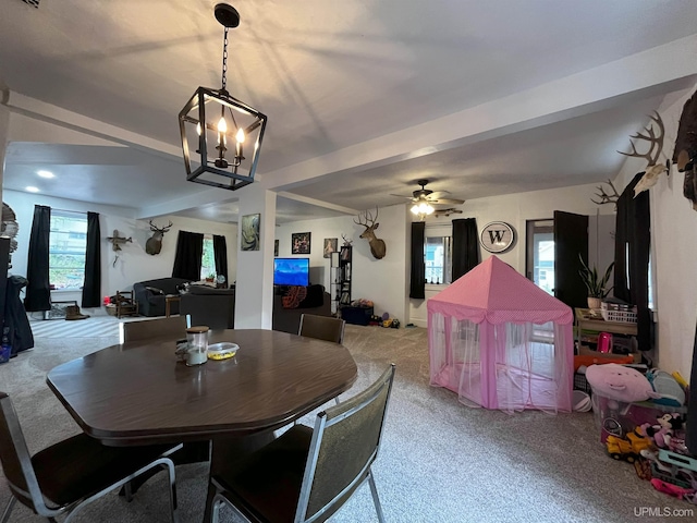 carpeted dining area featuring beamed ceiling and ceiling fan with notable chandelier