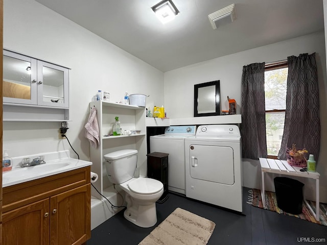 bathroom with vanity, washing machine and dryer, and toilet