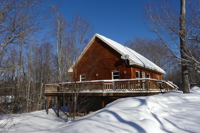 snow covered property with a deck