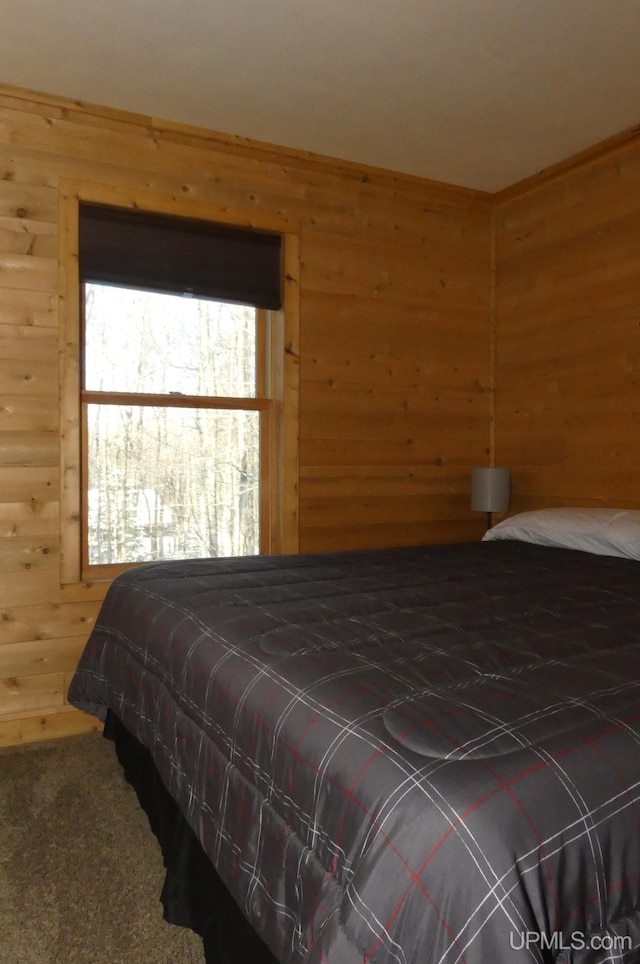 bedroom with carpet flooring and wooden walls