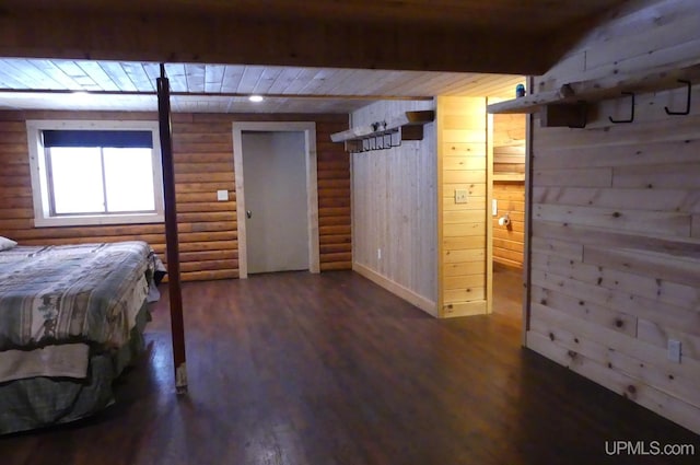 unfurnished bedroom with dark wood-type flooring, rustic walls, and wood walls