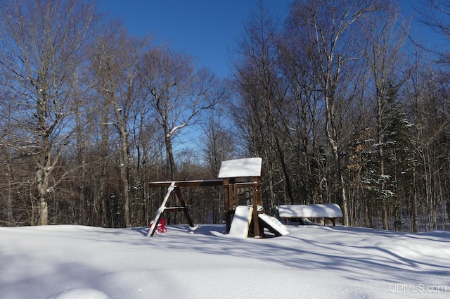 yard layered in snow with a playground