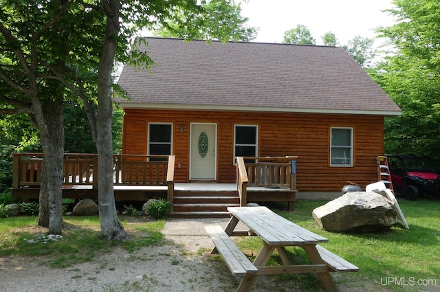 log home with roof with shingles and a wooden deck