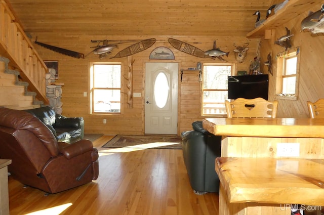 living room featuring wooden ceiling, wood walls, and light hardwood / wood-style floors