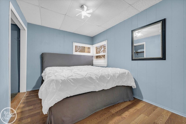 bedroom featuring hardwood / wood-style floors and a drop ceiling