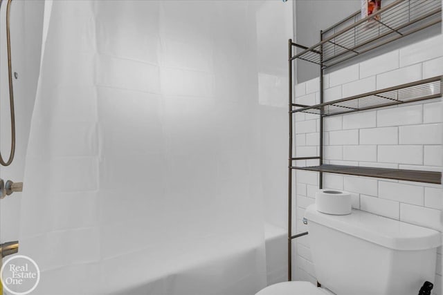 bathroom with shower / tub combo and toilet