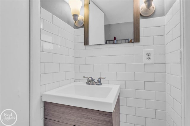 bathroom with tasteful backsplash, vanity, and tile walls