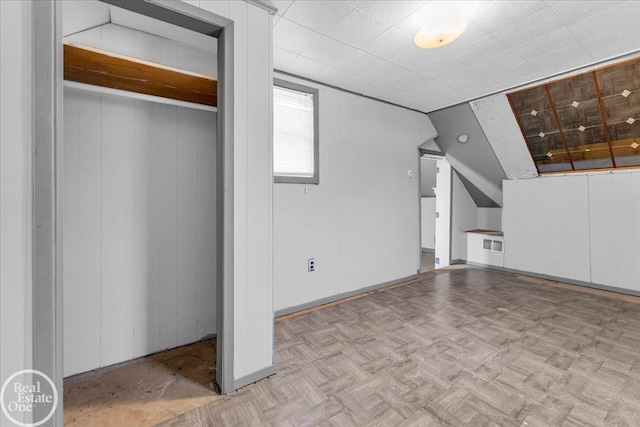 additional living space featuring light parquet floors and lofted ceiling