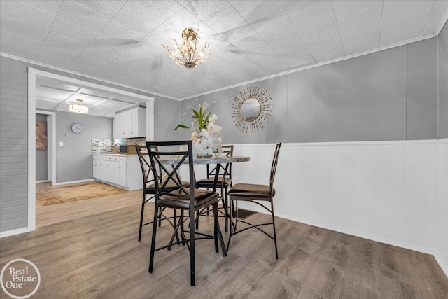 dining area featuring light hardwood / wood-style floors and ornamental molding