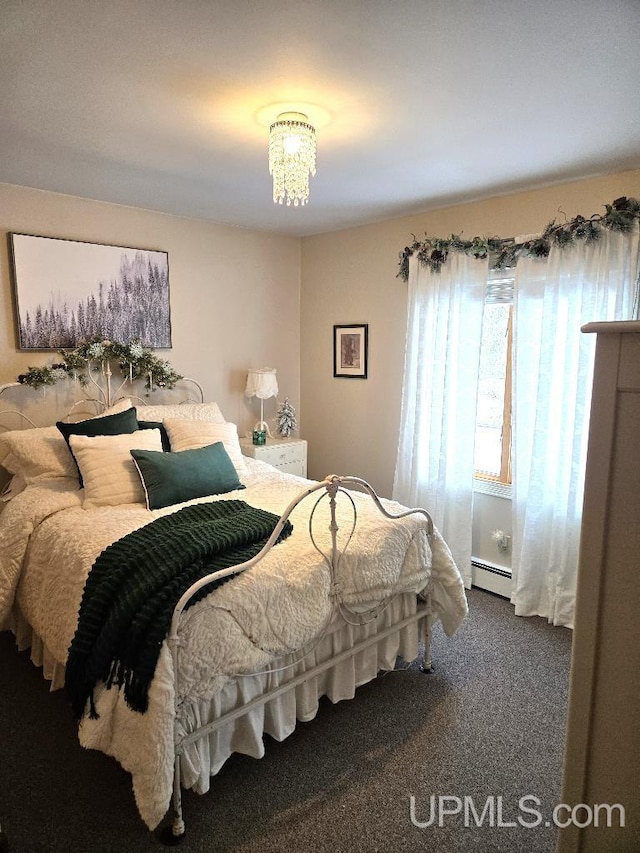 carpeted bedroom featuring baseboard heating and an inviting chandelier