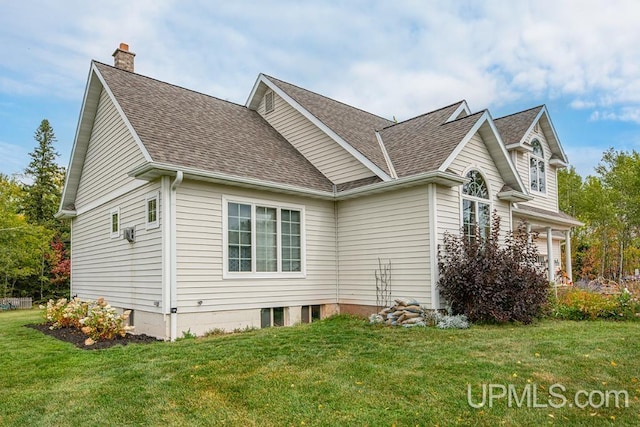 view of side of property featuring a lawn and a garage