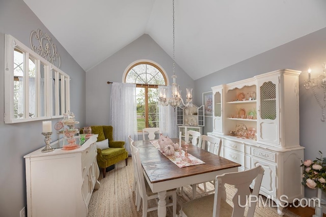 dining space featuring a notable chandelier, lofted ceiling, and light hardwood / wood-style flooring