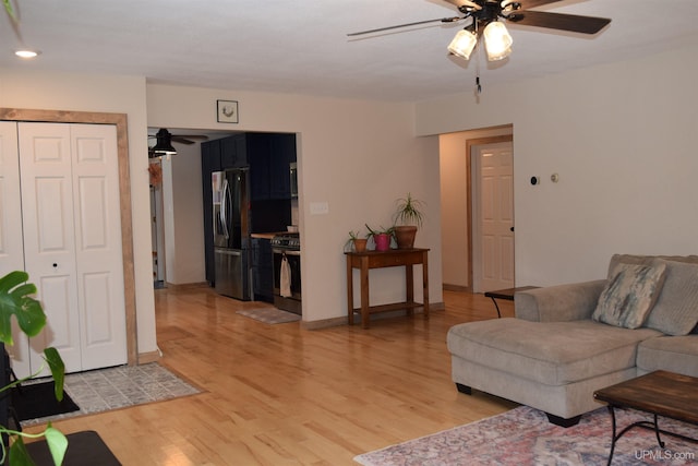 living room with ceiling fan and light wood-type flooring