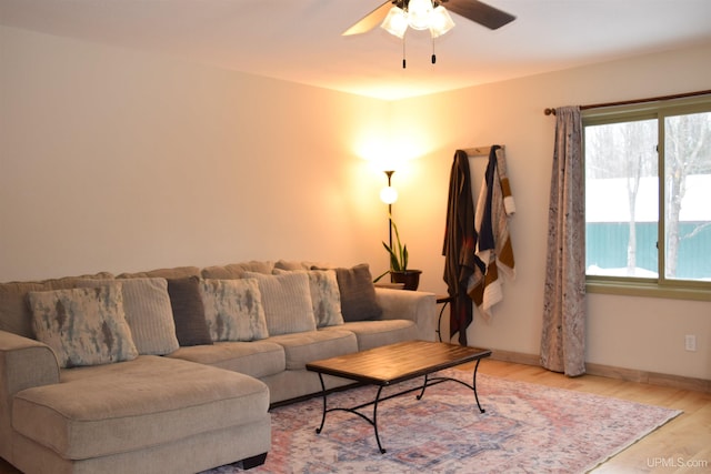 living room featuring ceiling fan, a water view, and light hardwood / wood-style floors