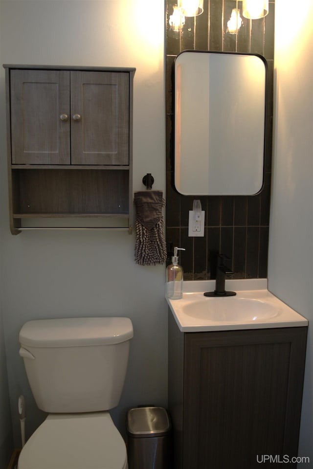 bathroom featuring vanity, tasteful backsplash, and toilet