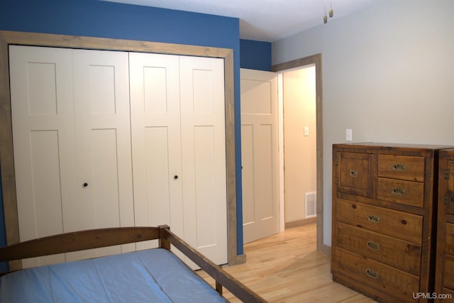 unfurnished bedroom with light wood-type flooring and a closet