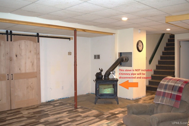 basement with a barn door and a wood stove