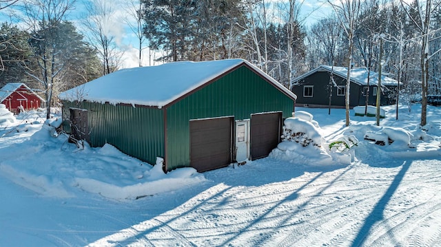 snow covered structure featuring a garage